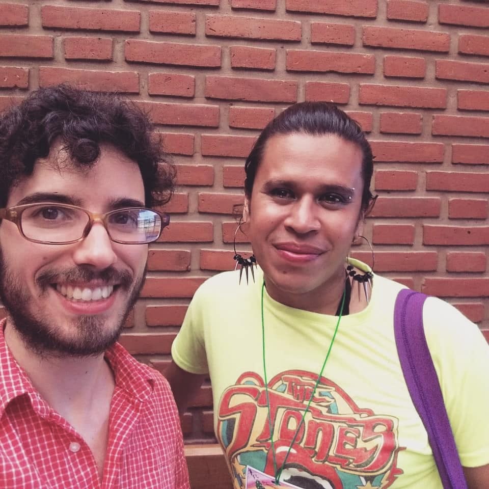 A picture of Fran Fernandez Romero and Marce Buttierez. Francisco is wearing a red checked shirt, and Marce is wearing a yellow graphic t-shirt.